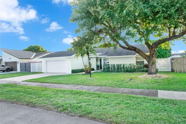 a front view of a house with a yard and trees