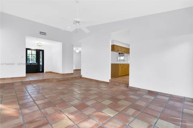a view of a big room with wooden floor and windows