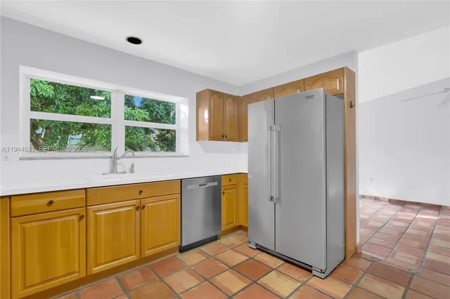 a view of a kitchen with wooden cabinets and a refrigerator