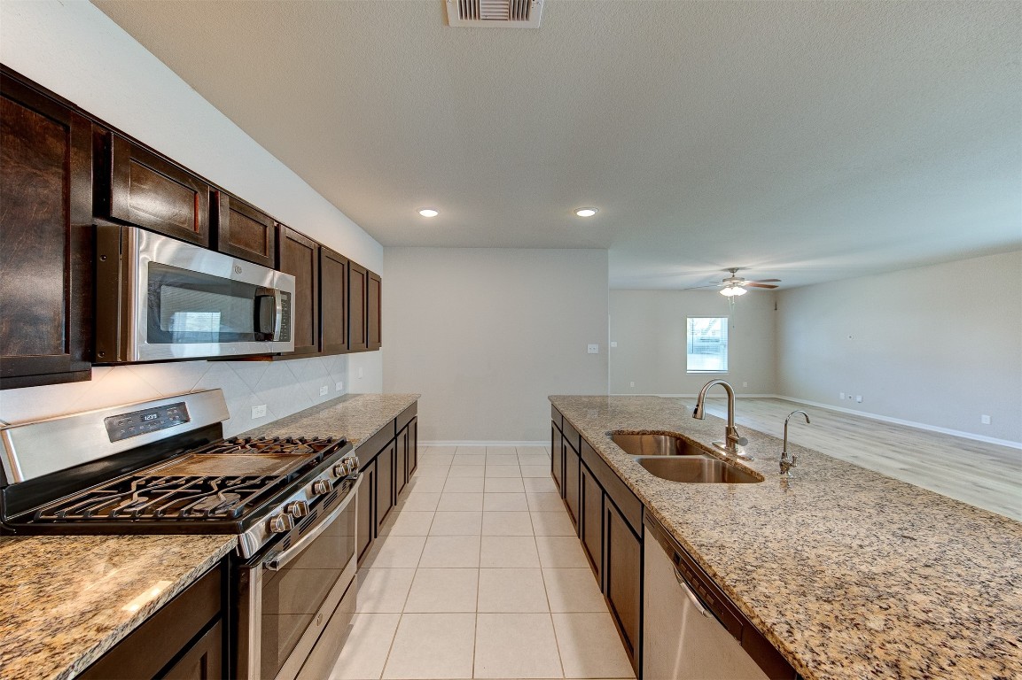 2164 Dale Street Alvin, TX 77511 - Photo 11 of 35 a kitchen with granite countertop stainless steel appliances sink stove microwave and cabinets