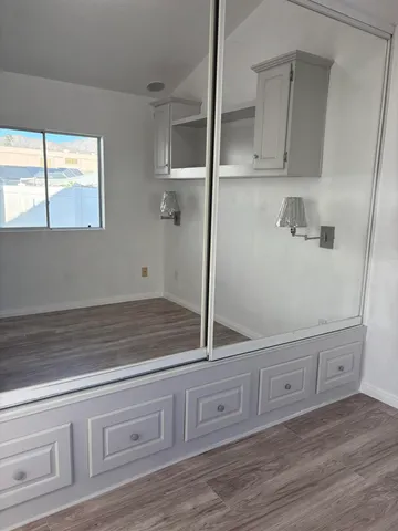 a view of a storage and utility room with wooden floor
