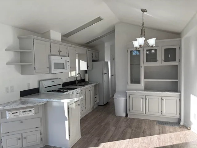 a kitchen with white cabinets and sink