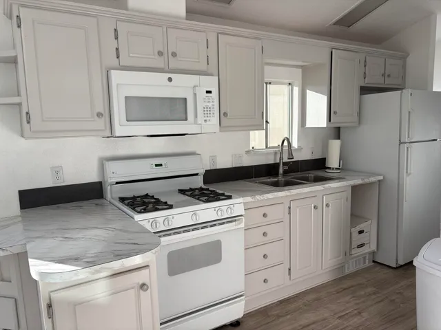 a kitchen with white cabinets and white appliances