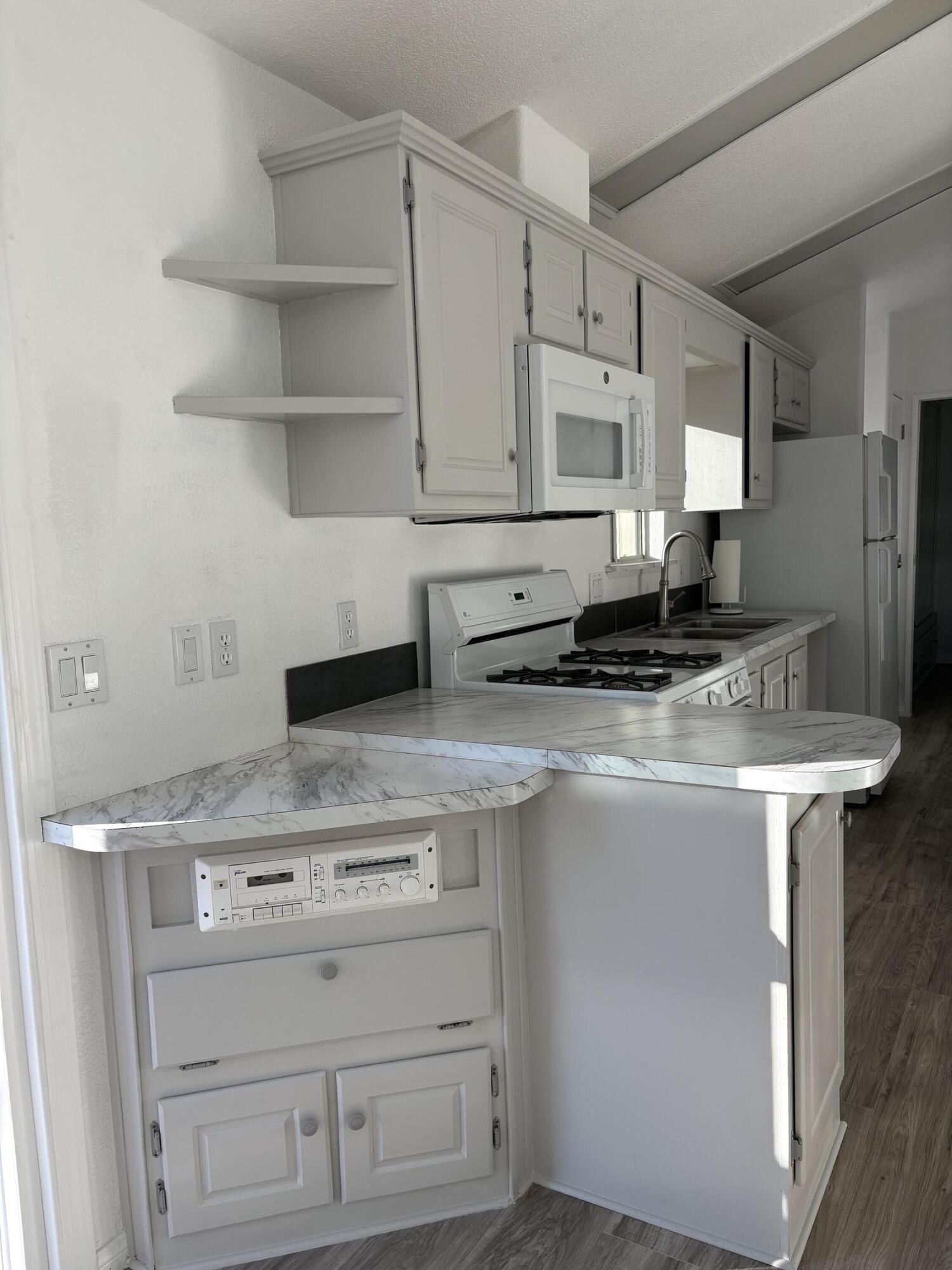 74711 Dillon Road, Unit 819 Desert Hot Springs, CA 92241 - Photo 8 of 41 a kitchen with stainless steel appliances granite countertop a sink stove and cabinets