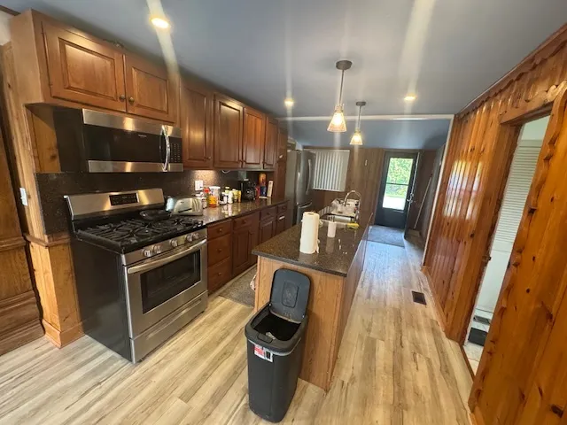 a kitchen with granite countertop stainless steel appliances and wooden floor