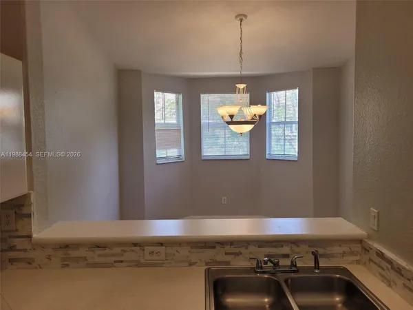 a kitchen with a sink and steel appliances