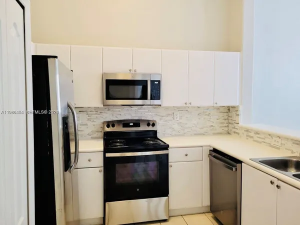 a kitchen with cabinets stainless steel appliances and a counter space