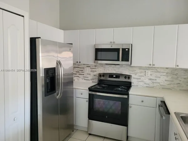 a kitchen with a refrigerator and a sink