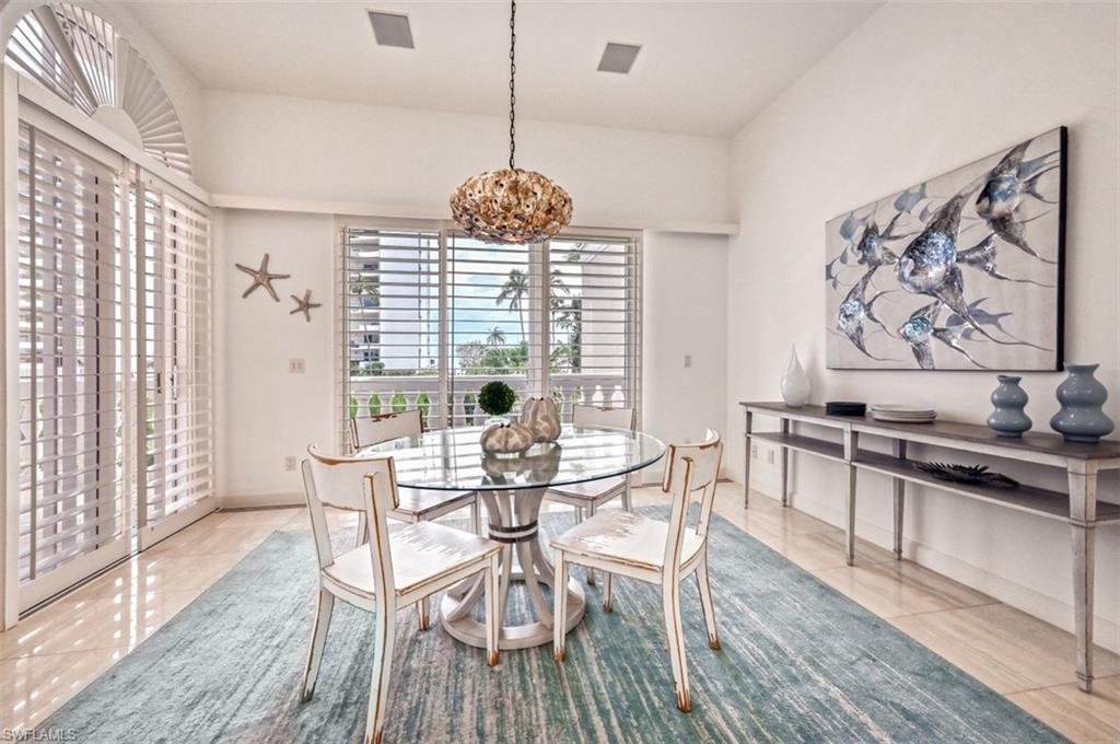 30 Casa Mar Lane Naples, FL 34103 - Photo 12 of 48 a view of a dining room with furniture wooden floor and chandelier