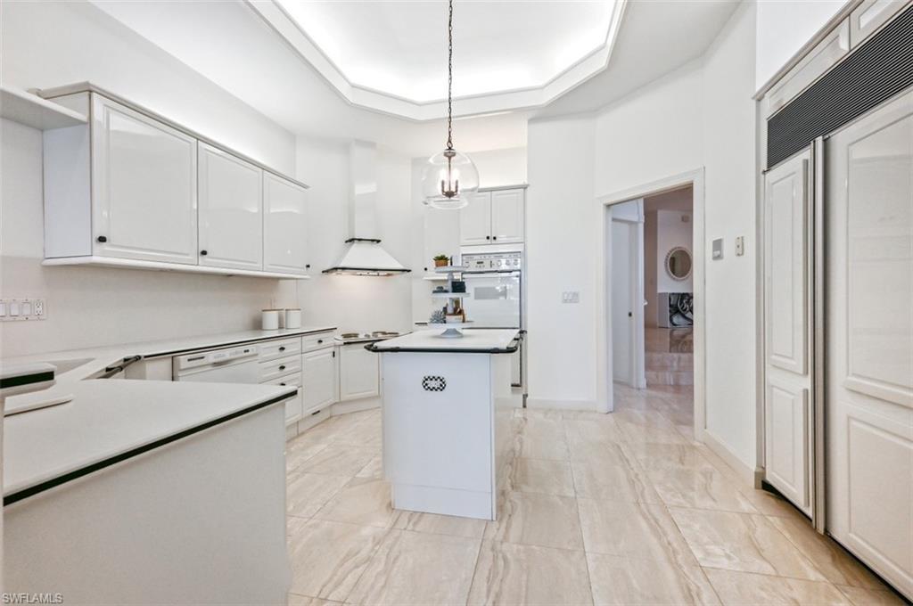 30 Casa Mar Lane Naples, FL 34103 - Photo 13 of 48 a kitchen with stainless steel appliances white cabinets and wooden floors