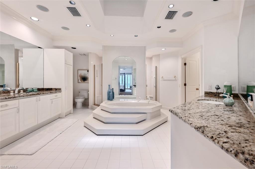 30 Casa Mar Lane Naples, FL 34103 - Photo 17 of 48 a spacious bathroom with a granite countertop sink and a mirror