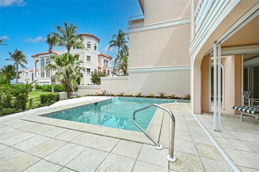 30 Casa Mar Lane Naples, FL 34103 - Photo 36 of 48 a view of a swimming pool with a lounge chair