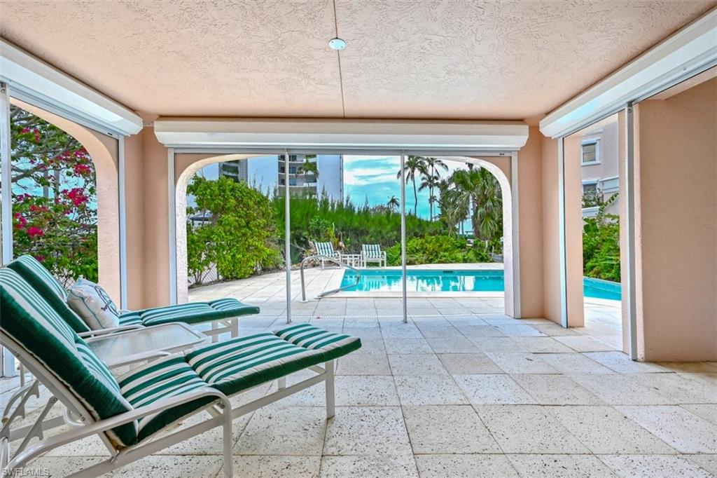 30 Casa Mar Lane Naples, FL 34103 - Photo 37 of 48 a swimming pool with outdoor seating and a garden