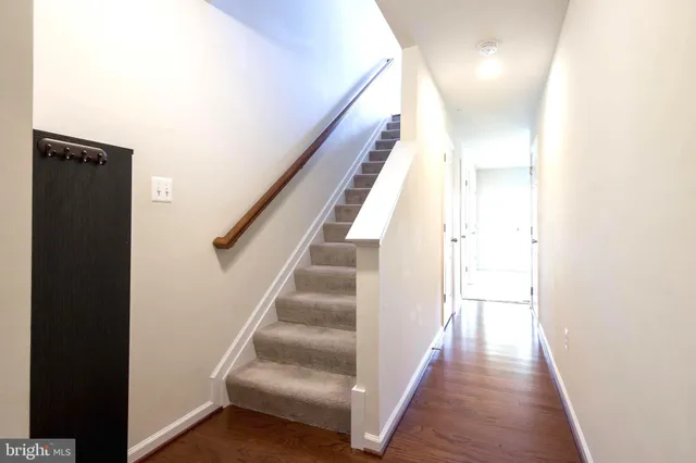 a view of a hallway with wooden floor and entryway