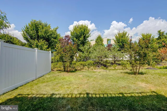 a view of swimming pool with seating area and trees in the background