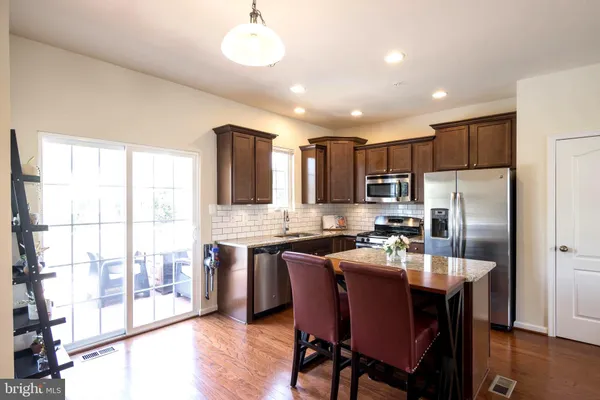 a kitchen with a table chairs refrigerator and cabinets