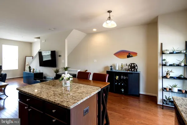 a kitchen with granite countertop kitchen island stainless steel appliances a sink and living room view