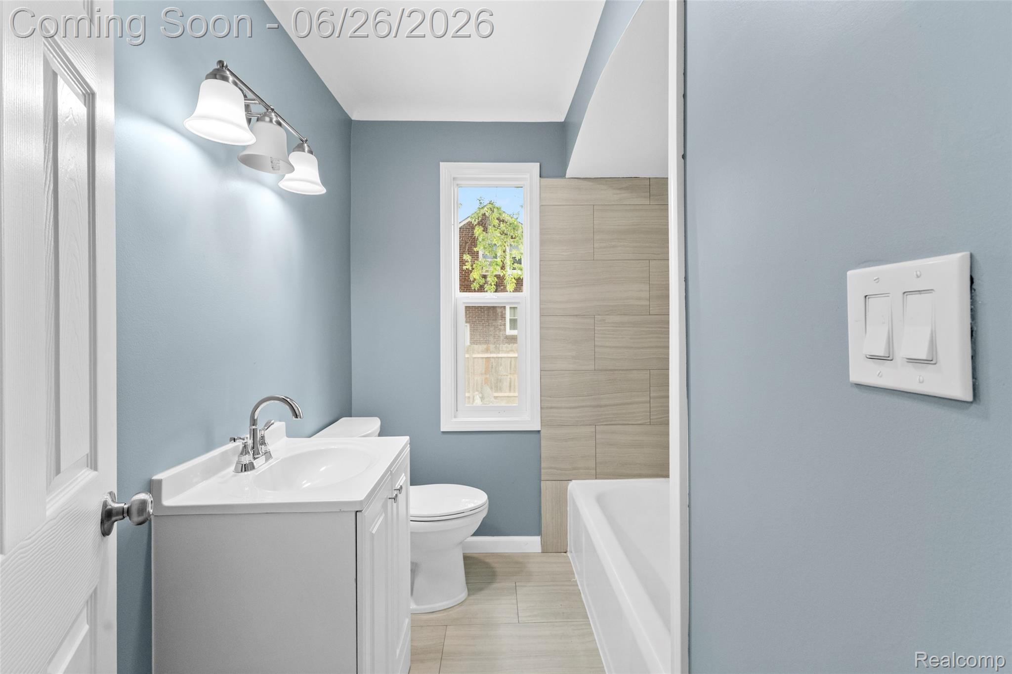 8310 Whitcomb Detroit, MI 48228 - Photo 16 of 26 Bathroom featuring light blue walls, a white vanity with integrated sink, a chrome faucet, and a toilet