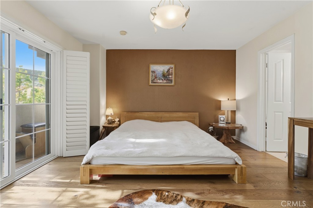5340 Las Virgenes Road, Unit 11 Calabasas, CA 91302 - Photo 19 of 46 a bedroom with a bed and wooden floor