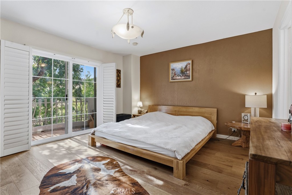 5340 Las Virgenes Road, Unit 11 Calabasas, CA 91302 - Photo 20 of 46 a bedroom with a bed and wooden floor