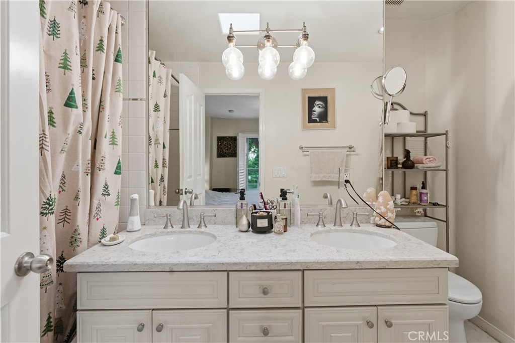 5340 Las Virgenes Road, Unit 11 Calabasas, CA 91302 - Photo 24 of 46 a bathroom with a granite countertop sink a toilet and mirror