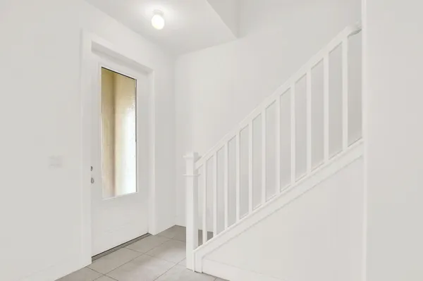 a view of staircase with railing and white walls