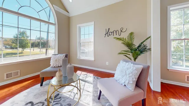 a view of a hallway with wooden floor and a kitchen