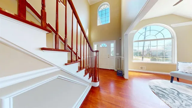 a dining room with wooden floor a chandelier a glass table and chairs