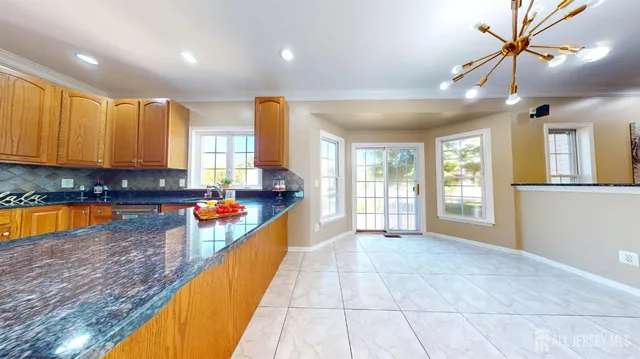 a large kitchen with stainless steel appliances granite countertop a refrigerator a oven and a sink