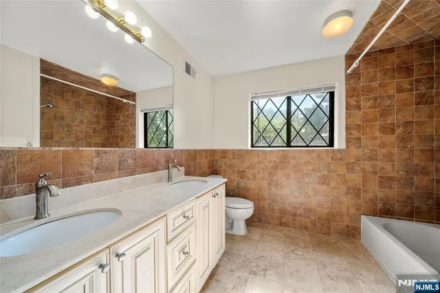 a bathroom with a sink a toilet and mirror