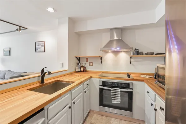 a kitchen with stainless steel appliances a sink stove and cabinets