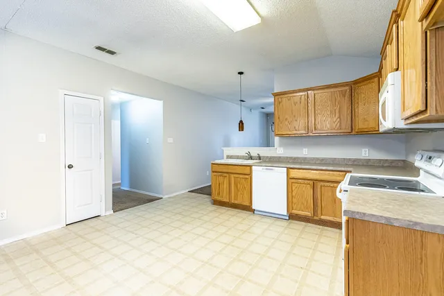 a kitchen with stainless steel appliances granite countertop a sink a stove cabinets and a window