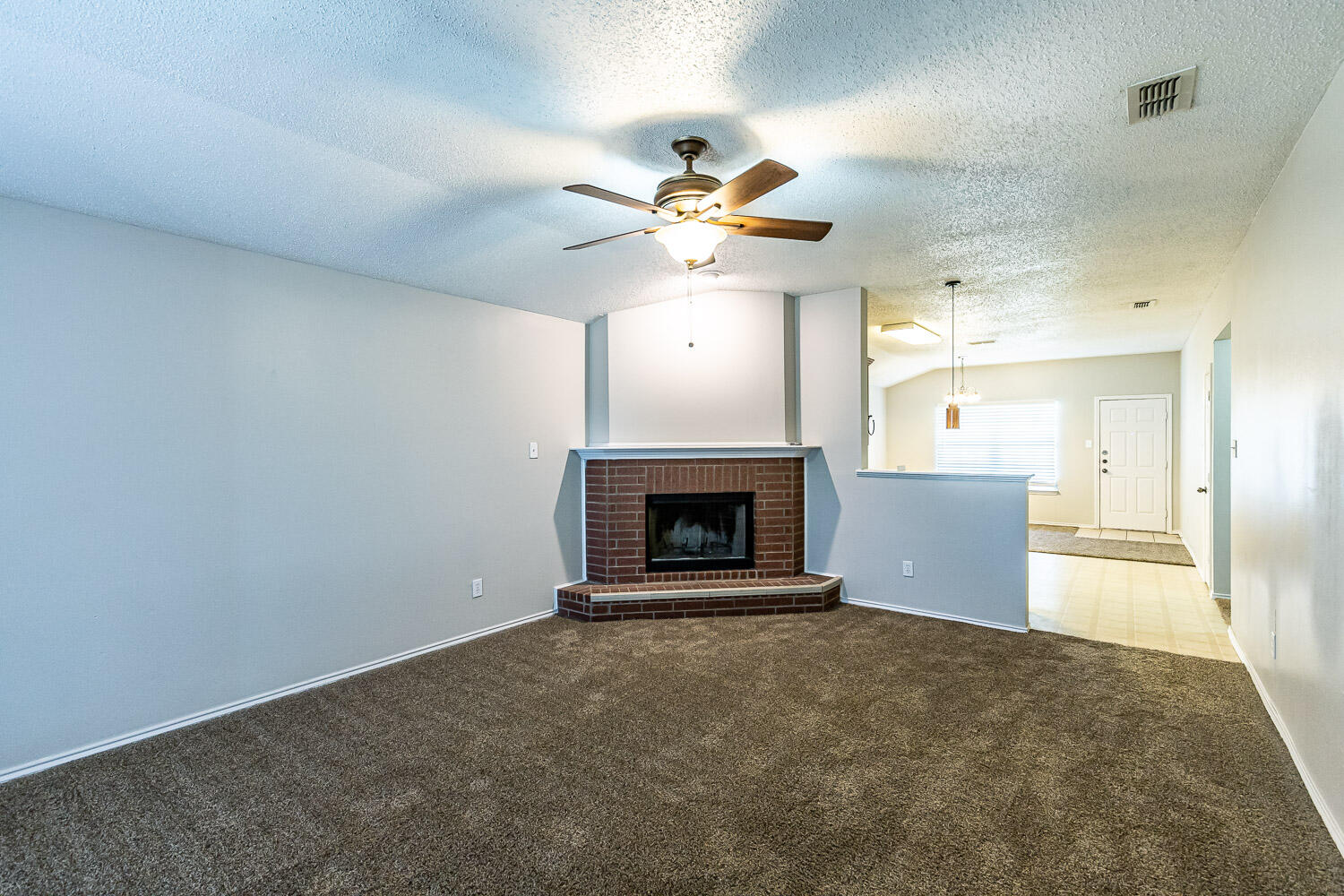 538 North Kirby Avenue Lubbock, TX 79416 - Photo 6 of 22 a view of an empty room and kitchen with fireplace