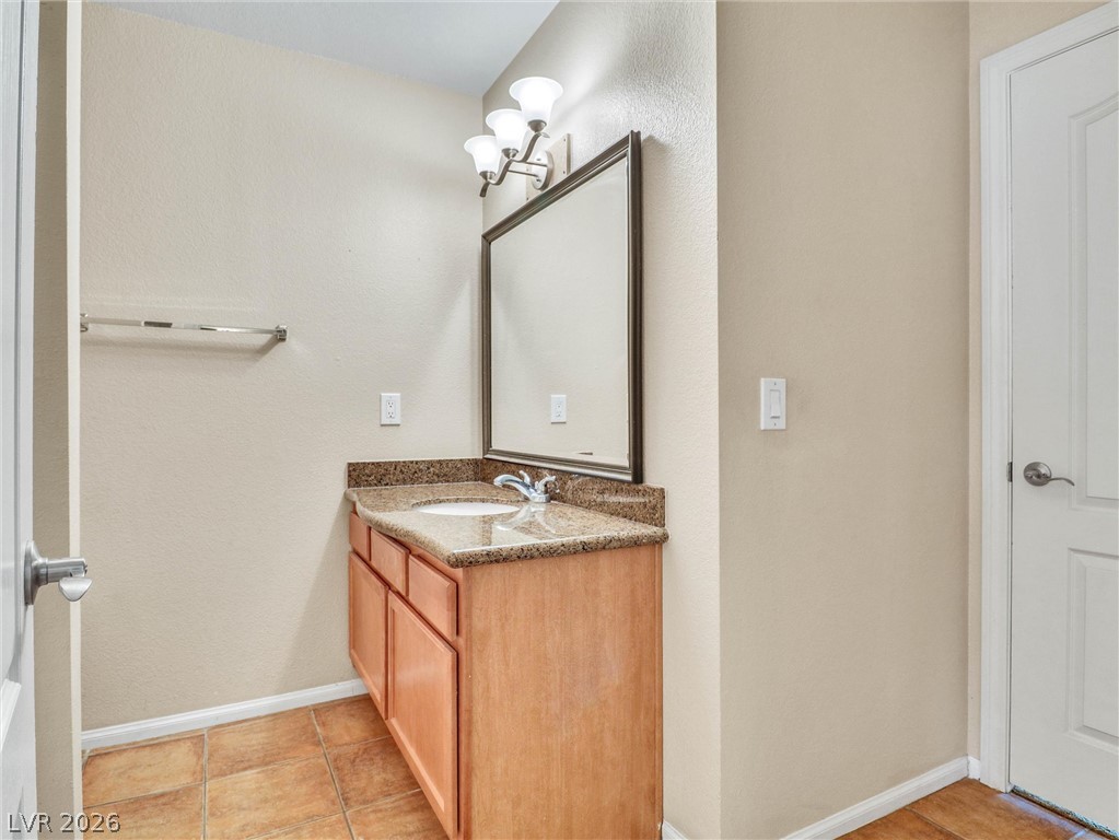 3145 East Flamingo Road, Unit 2129 Las Vegas, NV 89121 - Photo 25 of 43 A well-appointed bathroom features a single vanity with a granite countertop and a generous mirror.