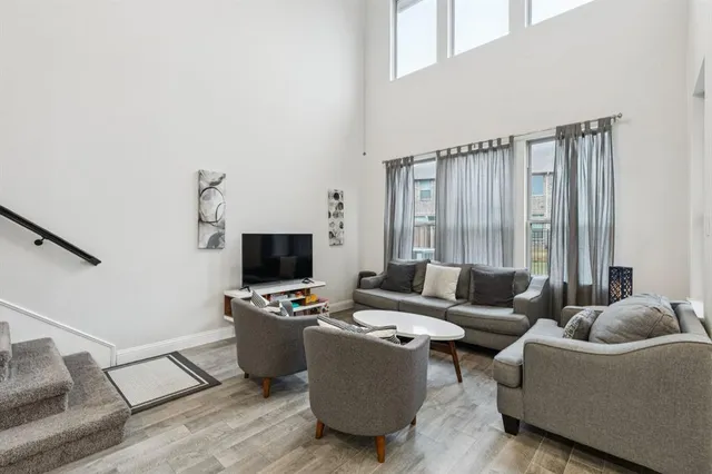 a living room with furniture kitchen view and a large window