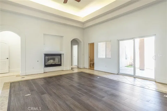 an empty room with wooden floor and fireplace