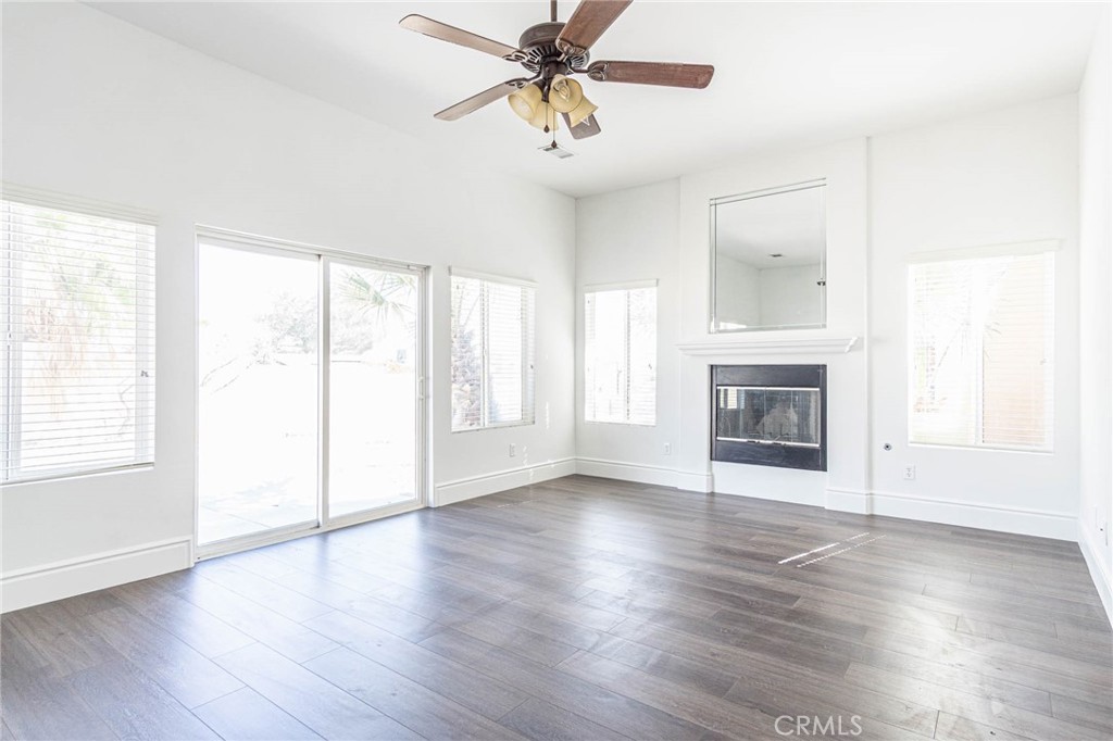 16233 Ridge View Drive Apple Valley, CA 92307 - Photo 20 of 50 an empty room with wooden floor fan and windows