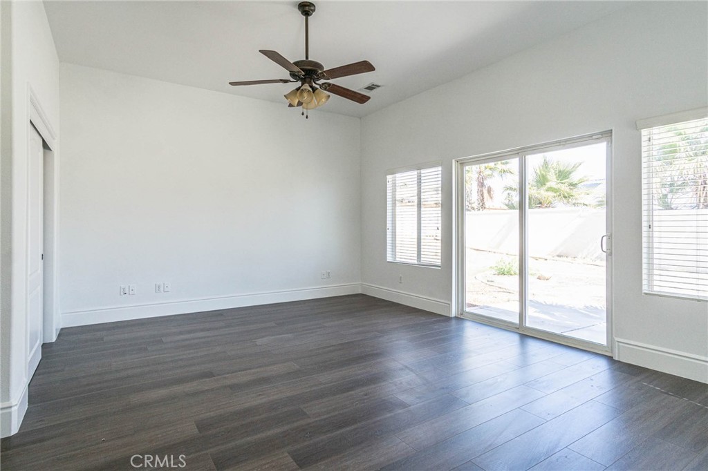 16233 Ridge View Drive Apple Valley, CA 92307 - Photo 21 of 50 an empty room with wooden floor fan and windows