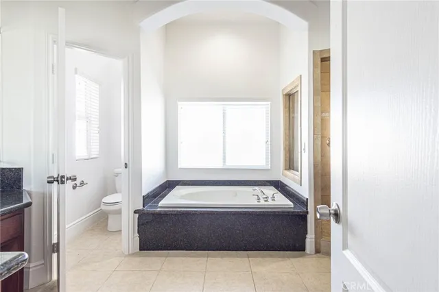 a spacious bathroom with a tub shower and toilet