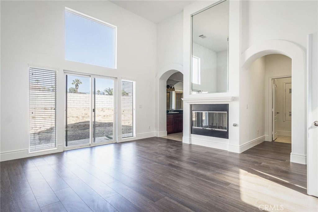 16233 Ridge View Drive Apple Valley, CA 92307 - Photo 29 of 50 an empty room with wooden floor and fireplace