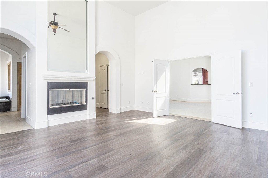 16233 Ridge View Drive Apple Valley, CA 92307 - Photo 30 of 50 an empty room with wooden floor fireplace and windows
