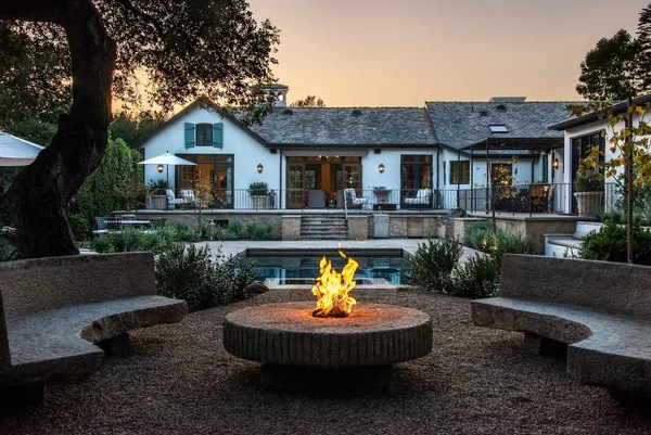 a view of a house with patio tub and chairs