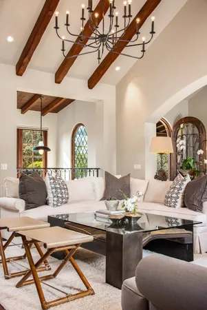 a living room with furniture kitchen view and a chandelier