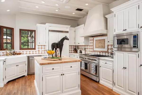 a kitchen with white cabinets and appliances
