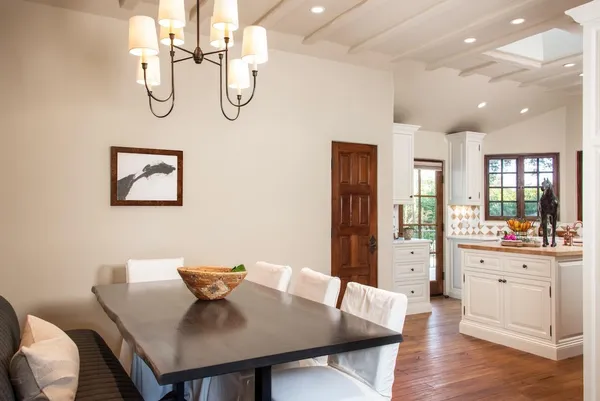 a view of a dining room with furniture a chandelier and wooden floor
