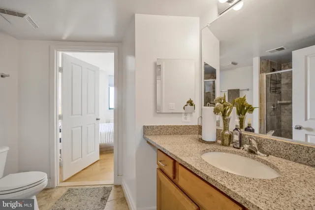 a bathroom with a granite countertop sink and a mirror