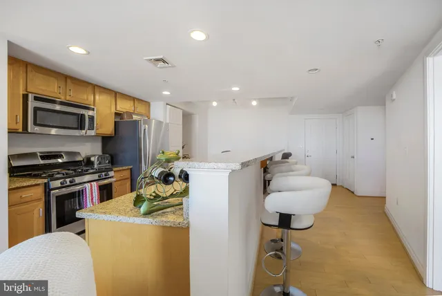 a kitchen with a refrigerator and a stove top oven