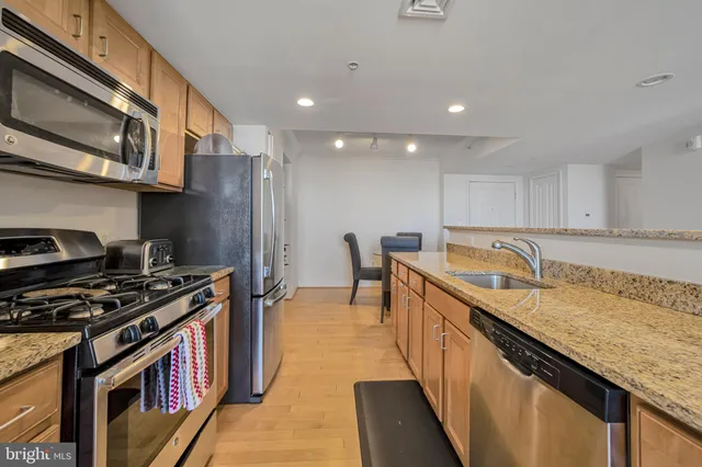 a kitchen with granite countertop stainless steel appliances and wooden cabinets