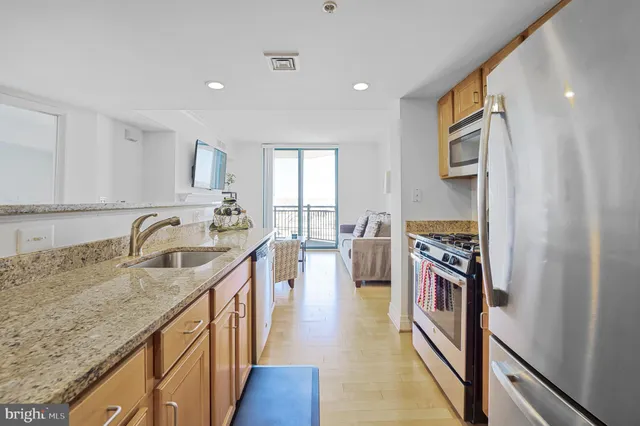 a kitchen with kitchen island granite countertop a sink stove and cabinets