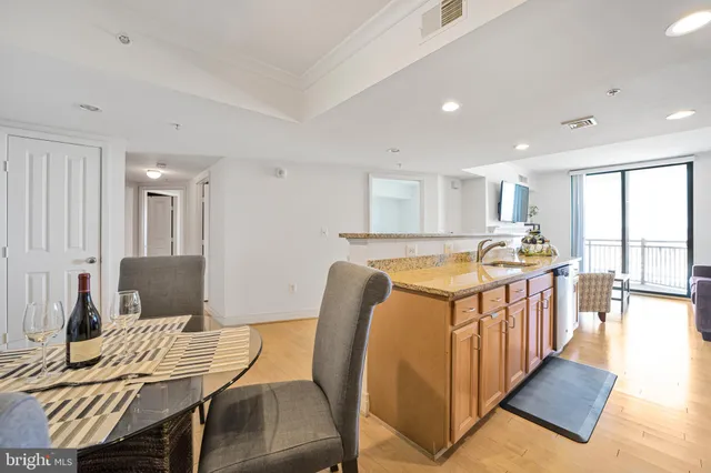 a open kitchen with stainless steel appliances kitchen island granite countertop a table and chairs in it